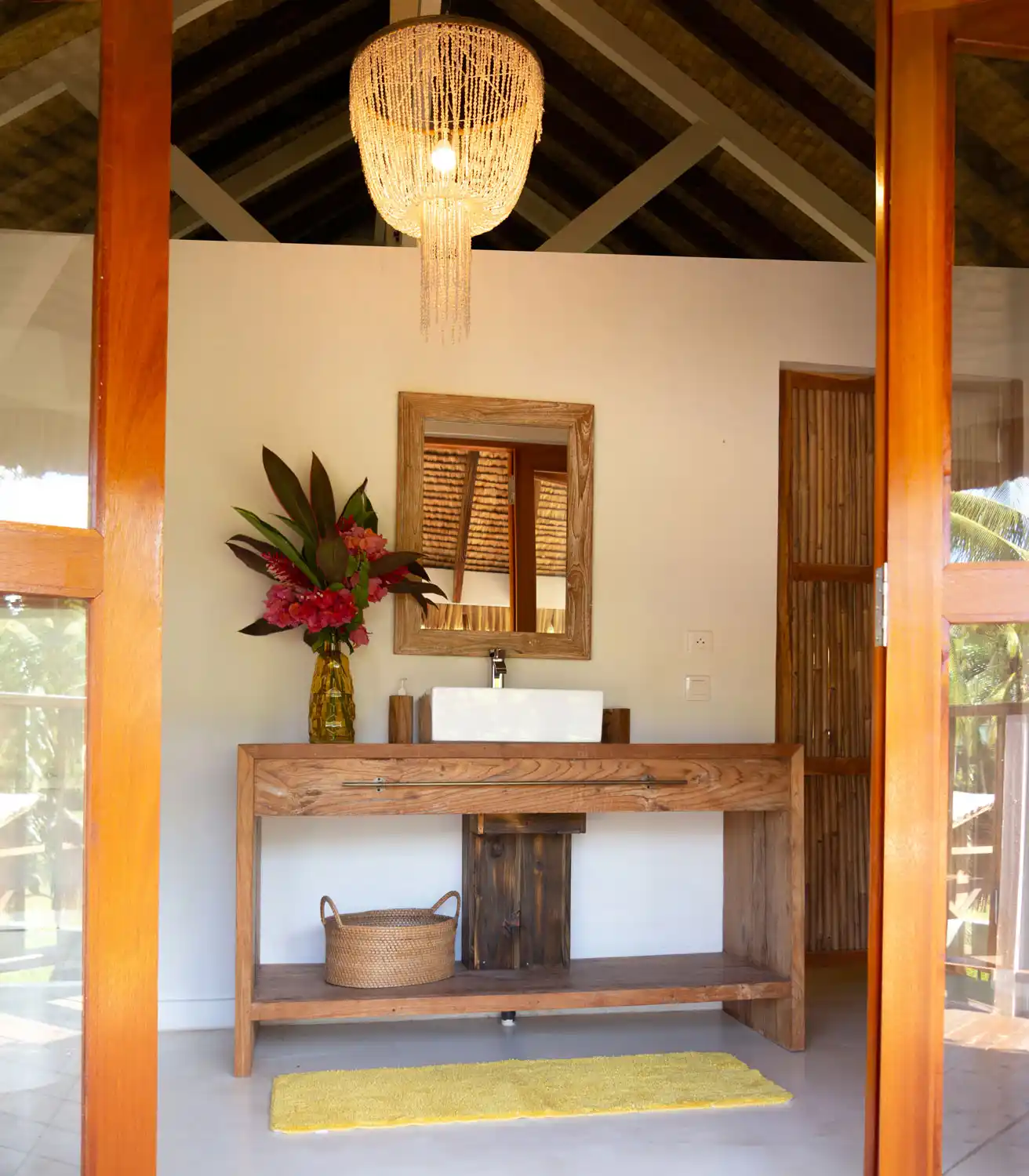 Elegant bathroom at Fare Kautinaki, lit by a seashell chandelier, adding a refined Polynesian touch to the ambiance of Fare Tiaia Moorea.