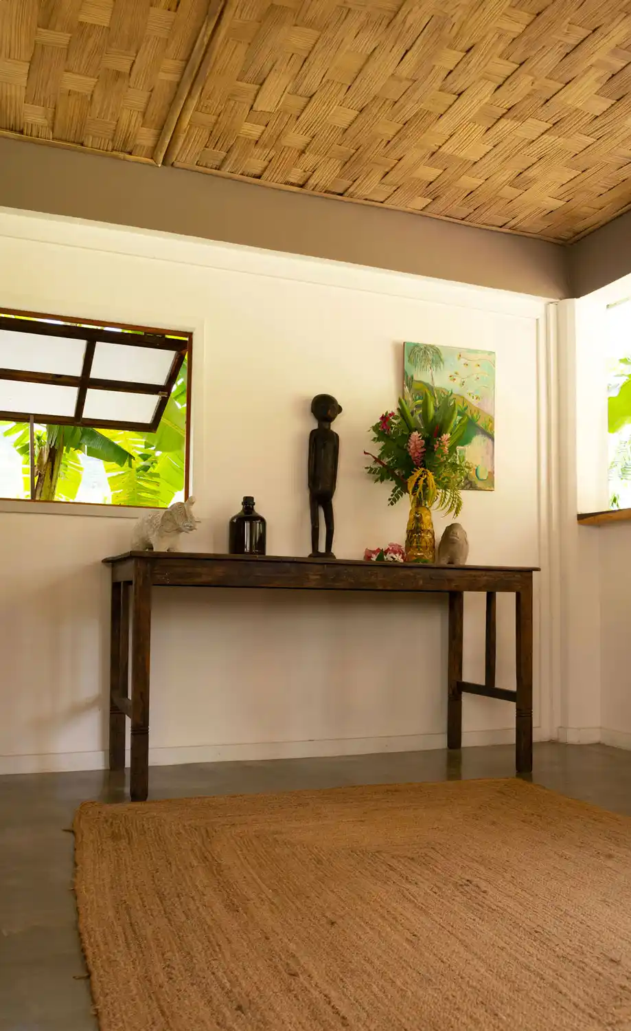 Interior view of the living room on the ground floor of Fare Kautinaki, illuminated by a painting reminiscent of Paul Gauguin that enriches the space with a cultural and aesthetic ambiance.