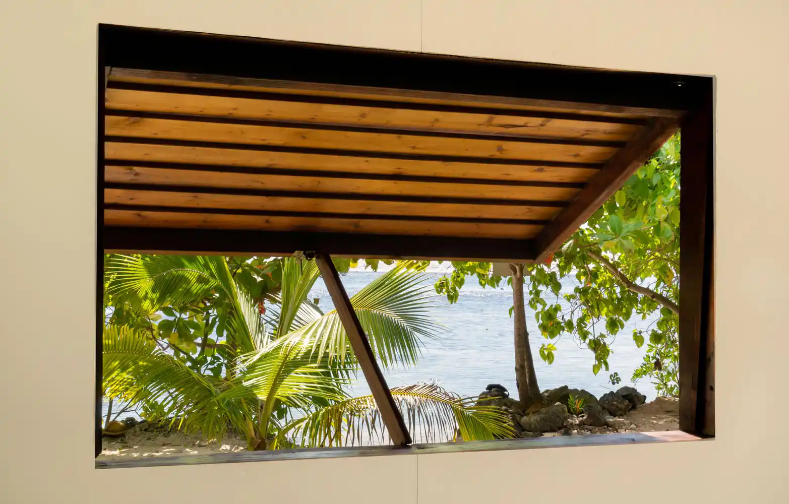 Depuis la fenêtre du Faré Totara, une vue captivante s'ouvre sur la végétation dense et le lagon scintillant de Fare Tiaia Moorea.