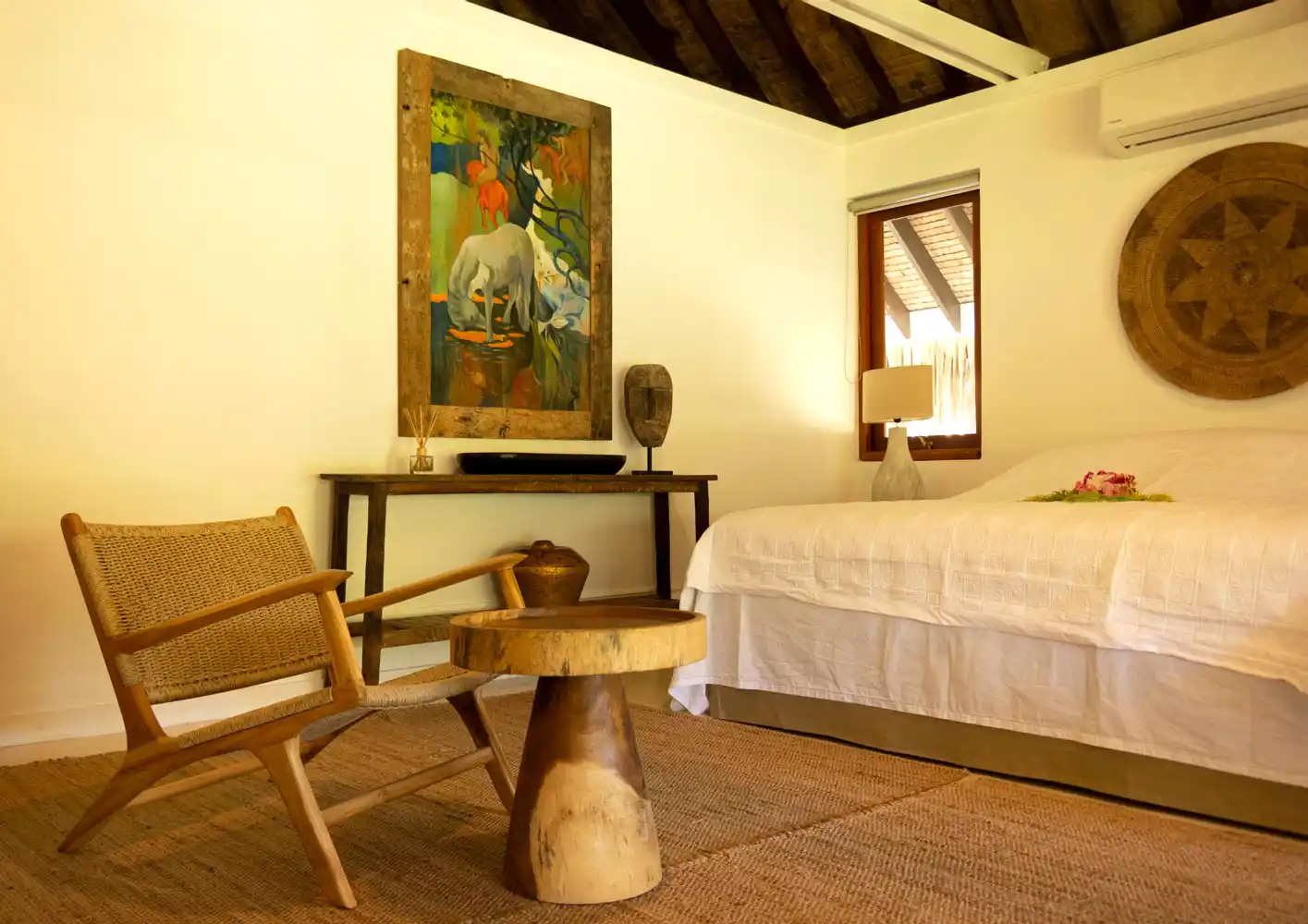 View of the small living area in the bedroom of the tropical bungalow at Fare Tiaia Moorea, enhanced by an inspiring painting reminiscent of Paul Gauguin, evoking an artistic and serene ambiance.